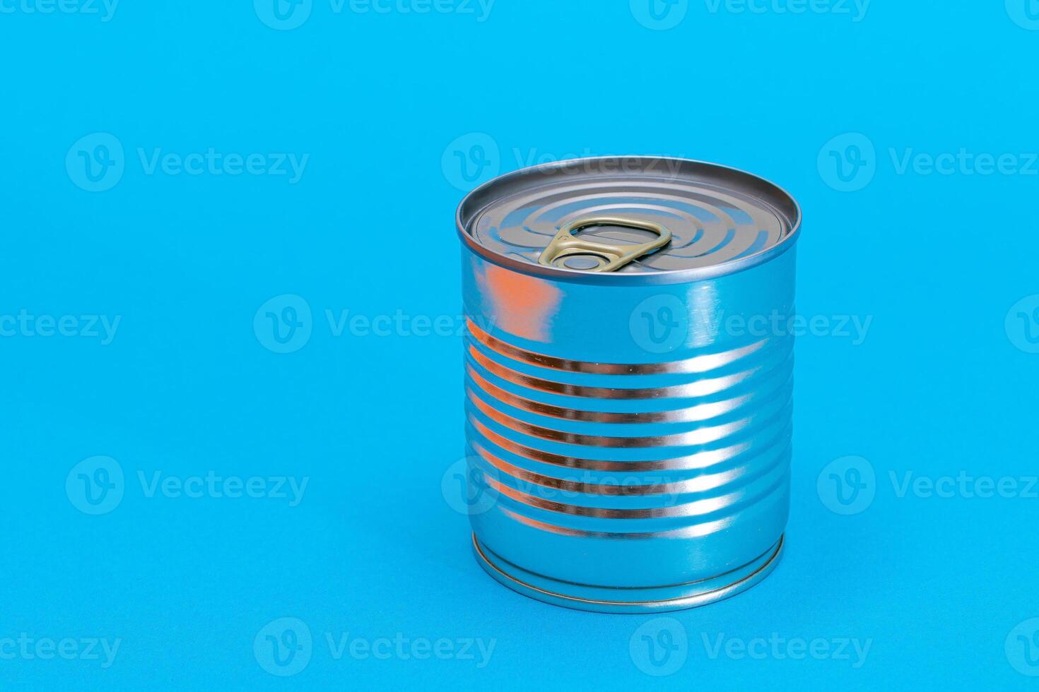 Unopened Tin Can with Blank Edge on Light Blue Background. Canned Food. Aluminum Can for Safe and Long Term Storage of Food. Steel Sealed Food Storage Container photo