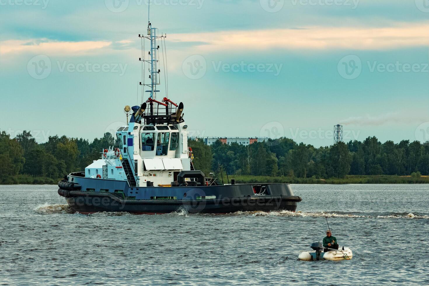 Black tug ship moving to the cargo terminal. Industrial service photo