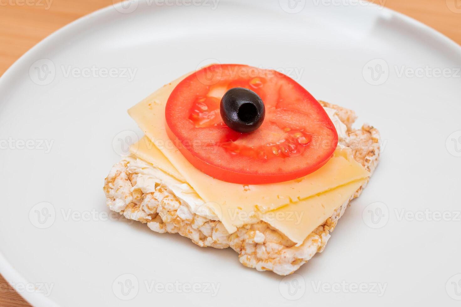 Rice Cake Sandwich with Tomato, Cheese and Olives on White Plate. Easy Breakfast. Diet Food. Quick and Healthy Sandwiches. Crispbread with Tasty Filling. Healthy Dietary Snack photo