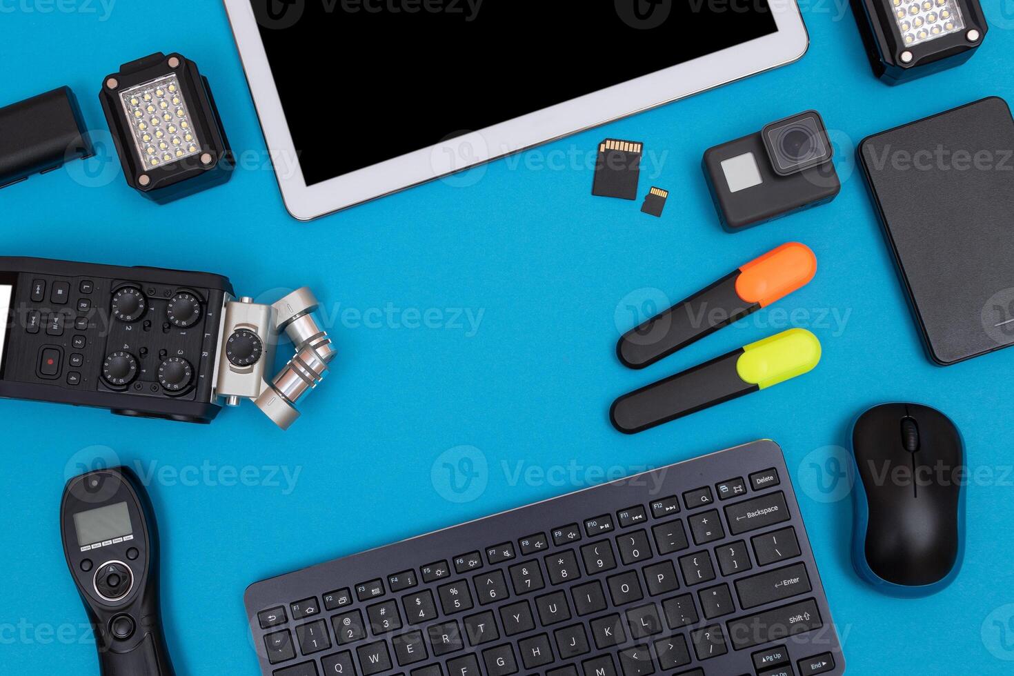 Top View of Photographer's, Videographer's or Blogger's Workplace. Digital Gadgets Lying on Blue Table - Flat Lay photo
