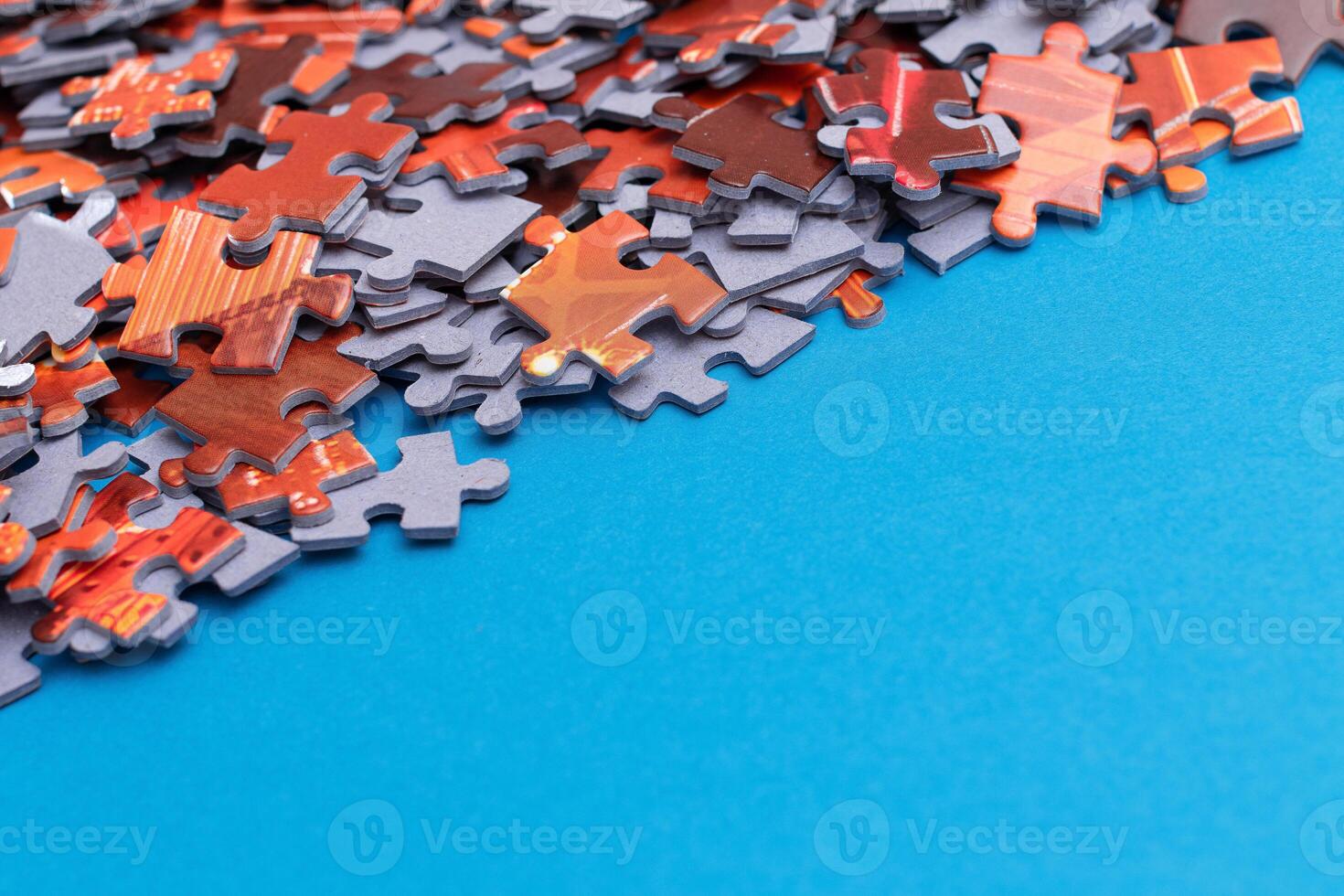 Mixed Pieces of a Colorful Jigsaw Puzzle Lie on the Blue Background With Copy Space - Strategy and Solving Problem Concept photo