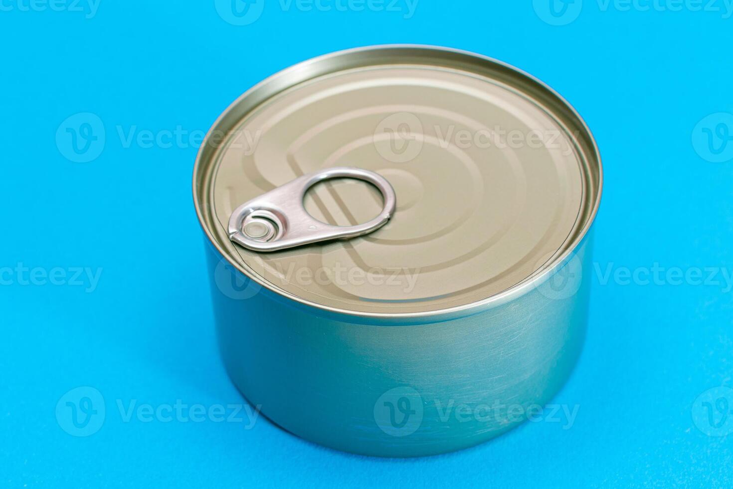 Unopened Tin Can with Blank Edge on Light Blue Background. Canned Food. Aluminum Can for Safe and Long Term Storage of Food. Steel Sealed Food Storage Container photo