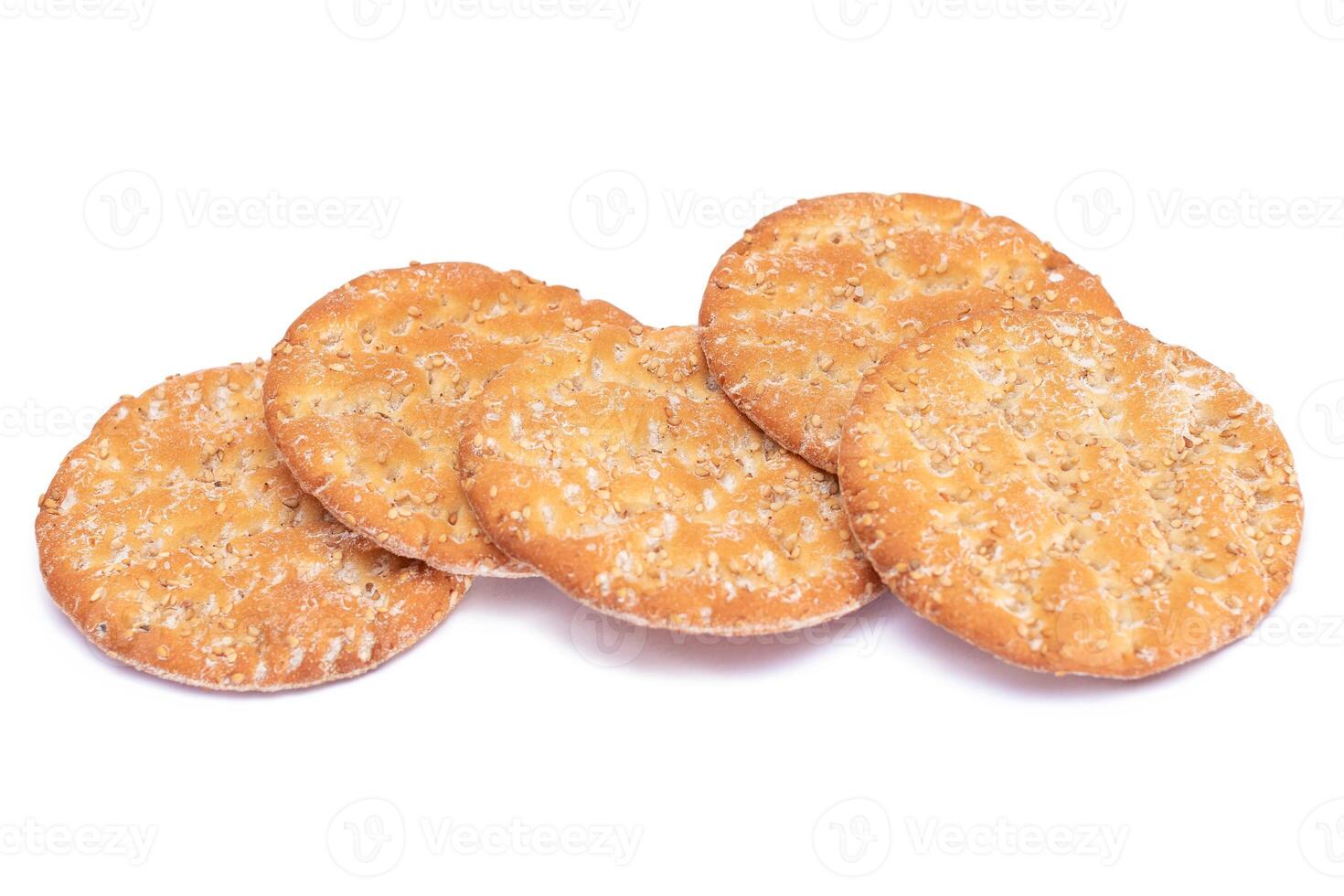 A Heap of Round Salt Crackers with Sesame Isolated on White Background. Dry Snacks - Isolation photo