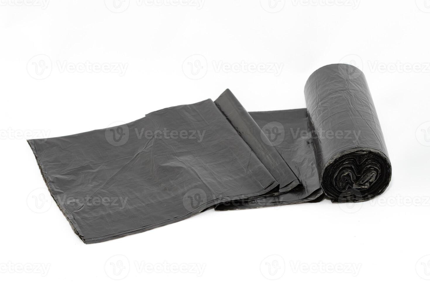 Black Polyethylene Garbage Bags on White Background - Close-Up. The Roll of Plastic Junk Package photo