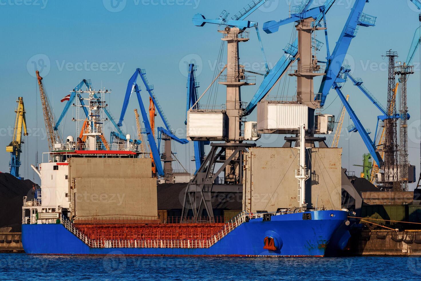 Blue cargo ship loading in the port of Riga, Europe photo