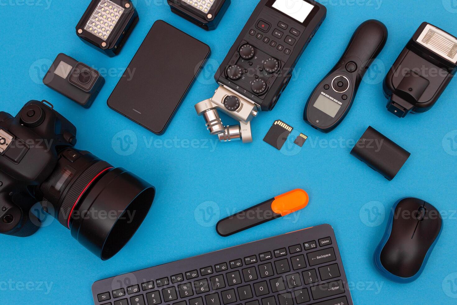 Top View of Photographer's, Videographer's or Blogger's Workplace. Digital Gadgets Lying on Blue Table - Flat Lay photo