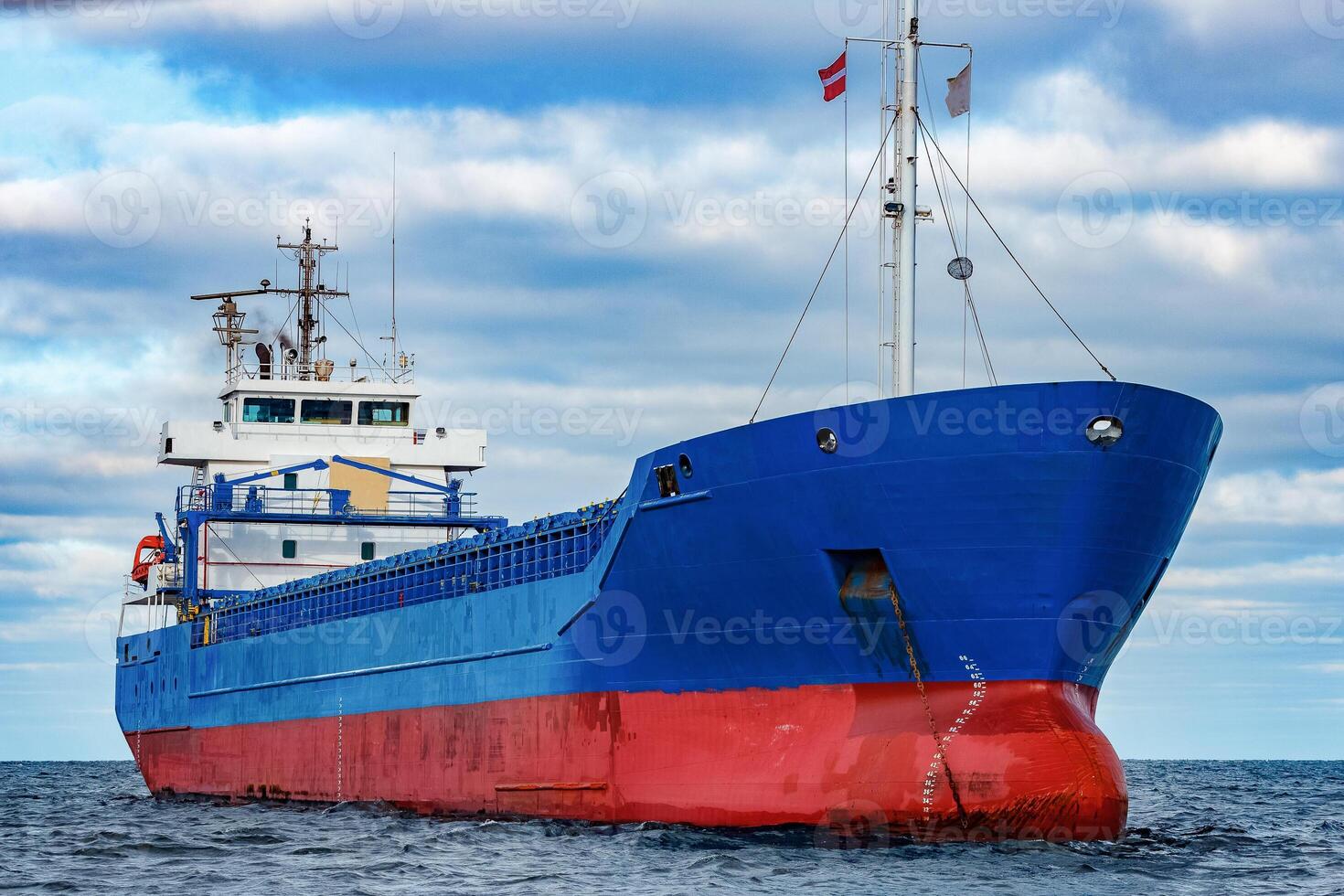 Blue cargo ship moored in still Baltic sea water photo