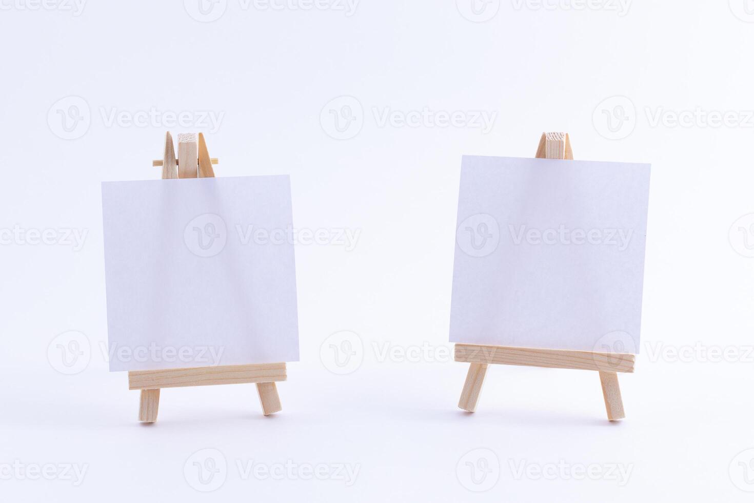 Two Wooden Easels Miniature with Blank White Square Canvas for Artists and Painters - Mockup. Mini Wooden Stand with Clean Artboard on White Background, Copy Space photo