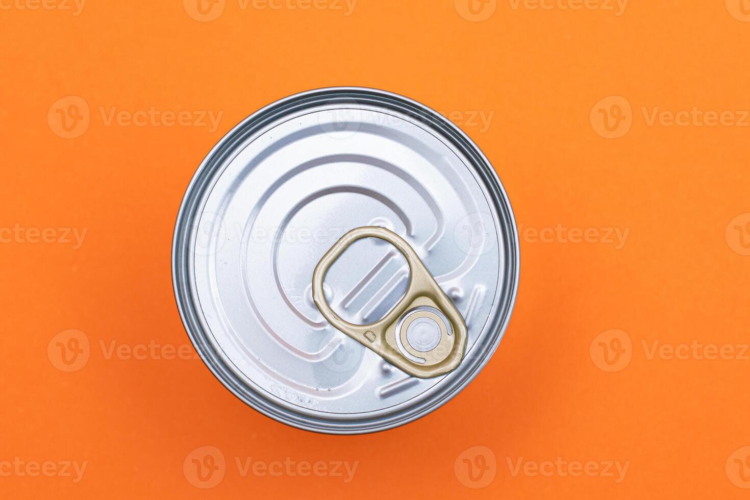 Unopened Tin Can with Blank Edge on Orange Background. Canned Food. Aluminum Can for Safe and Long Term Storage of Food. Steel Sealed Food Storage Container photo