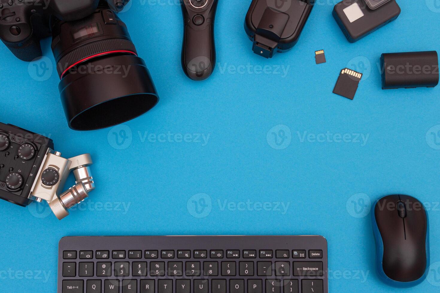 Top View of Photographer's, Videographer's or Blogger's Workplace. Digital Gadgets Lying on Blue Table - Flat Lay photo