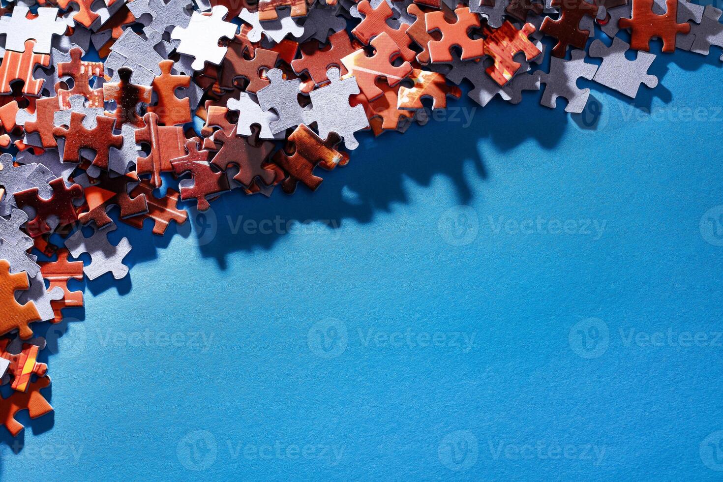 Mixed Pieces of a Colorful Jigsaw Puzzle Lie on the Blue Background With Copy Space - Strategy and Solving Problem Concept photo