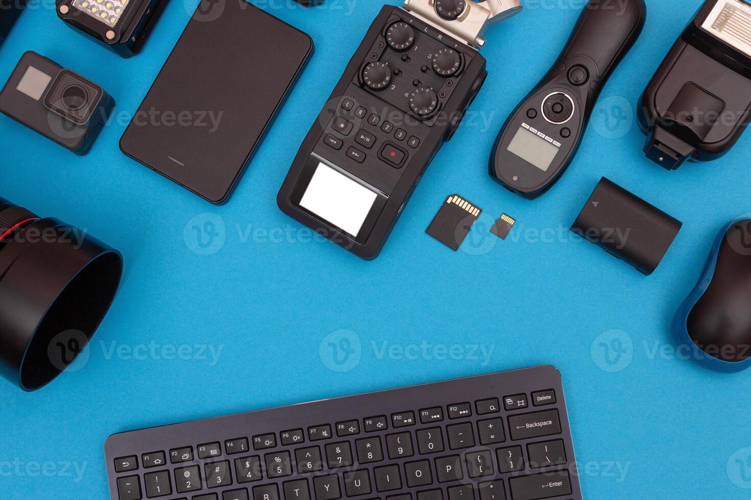 Top View of Photographer's, Videographer's or Blogger's Workplace. Digital Gadgets Lying on Blue Table - Flat Lay photo