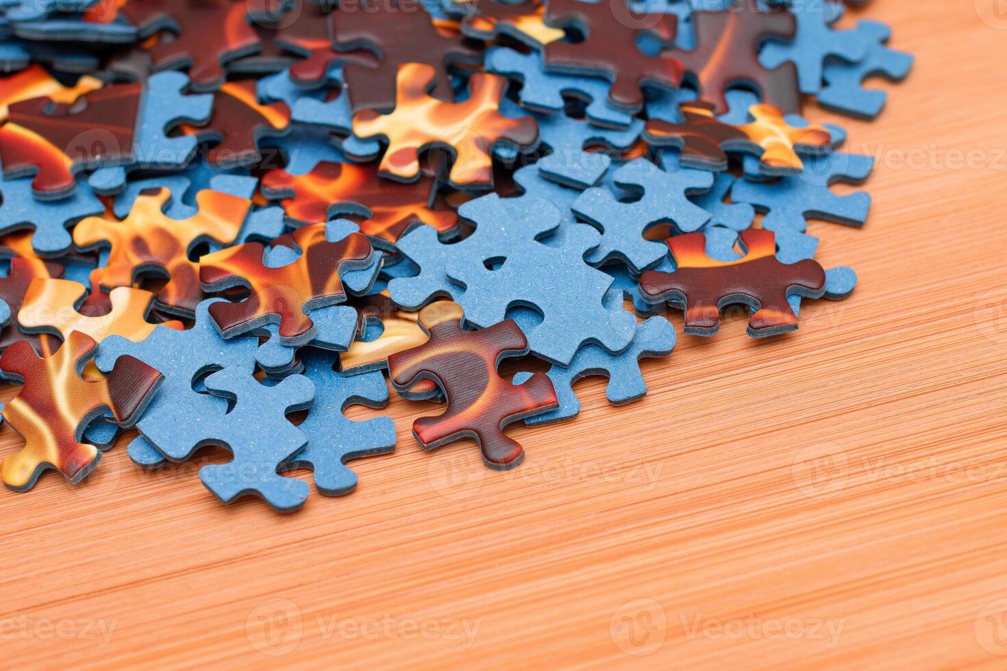 Colorful Pieces of a Mixed Jigsaw Puzzle Lie on the Wooden Table - Strategy and Solving Problem Concept photo