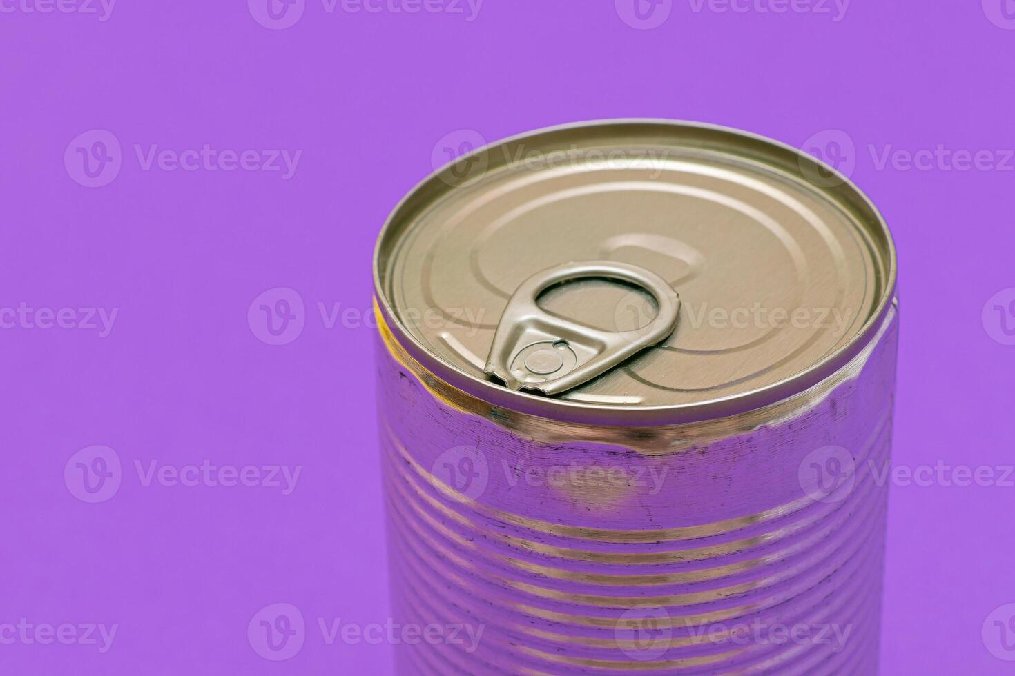 Unopened Tin Can with Blank Edge on Violet Background. Canned Food. Aluminum Can for Safe and Long Term Storage of Food. Steel Sealed Food Storage Container photo