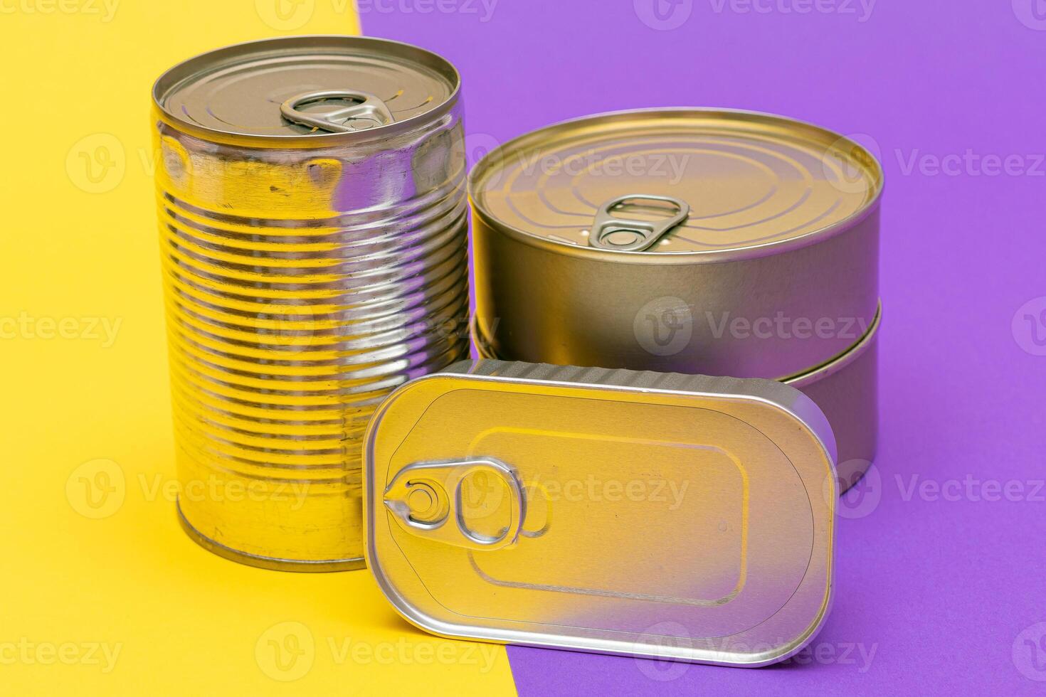 A Group of Stacked Tin Cans with Blank Edges on Split Yellow and Violet Background. Canned Food. Different Aluminum Cans for Safe and Long Term Storage of Food. Steel Sealed Food Storage Containers photo