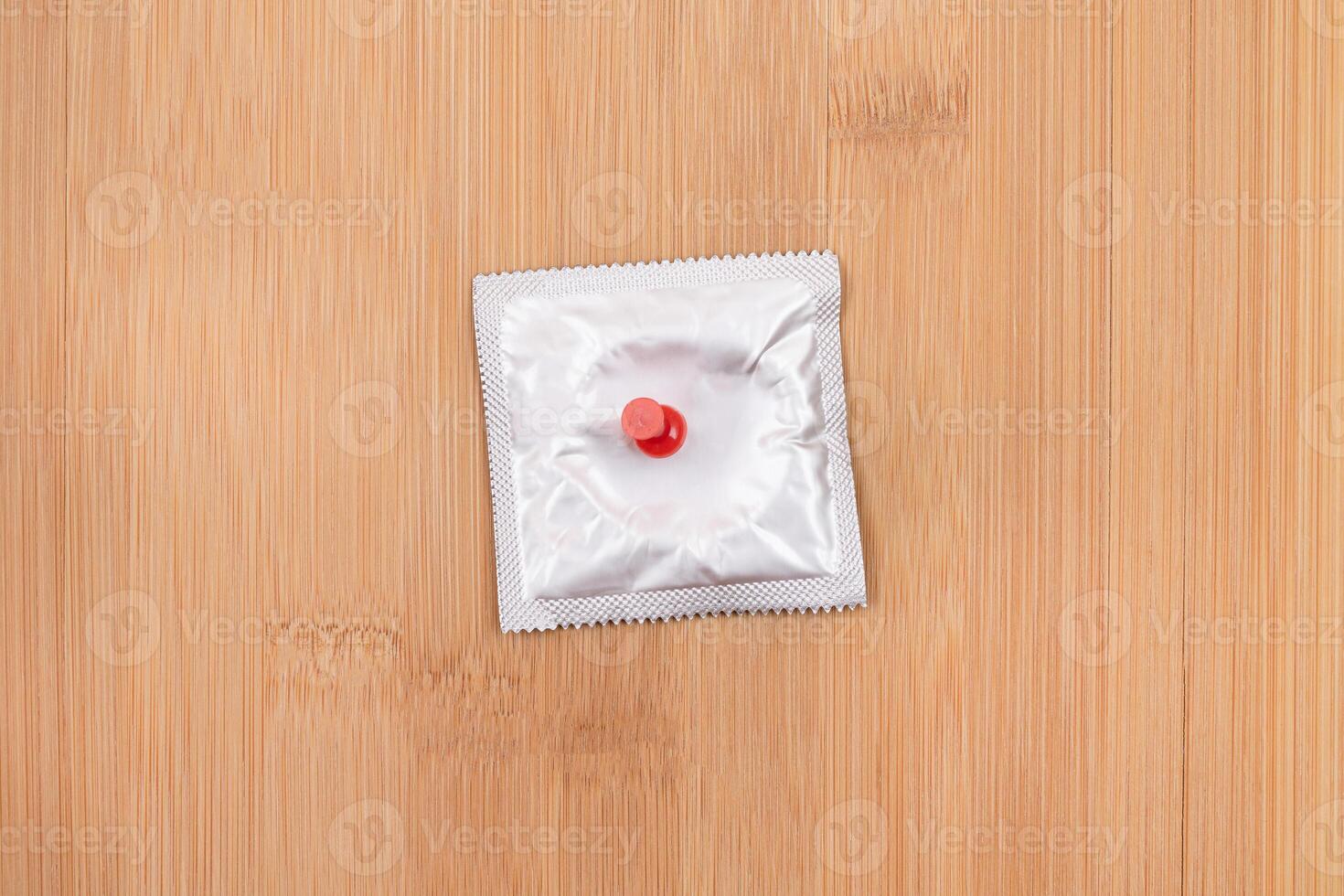 A Joke on Colleagues, Freebie or a Defective Condom - Packaged Latex Condom Pinned to a Wooden Message Board photo
