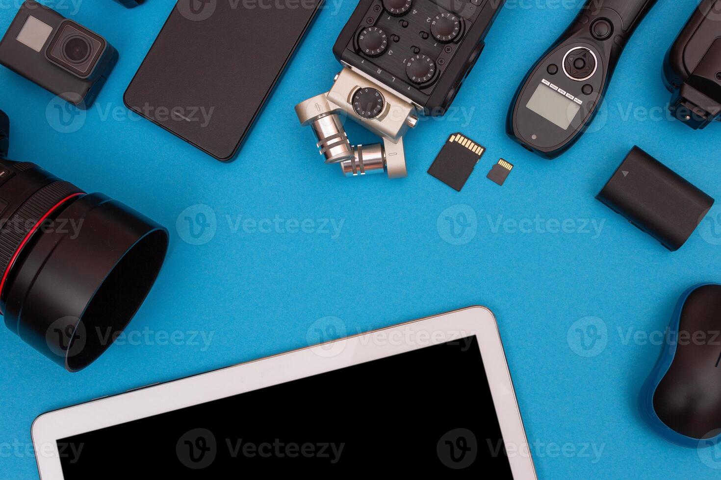 Top View of Photographer's, Videographer's or Blogger's Workplace. Digital Gadgets Lying on Blue Table - Flat Lay photo
