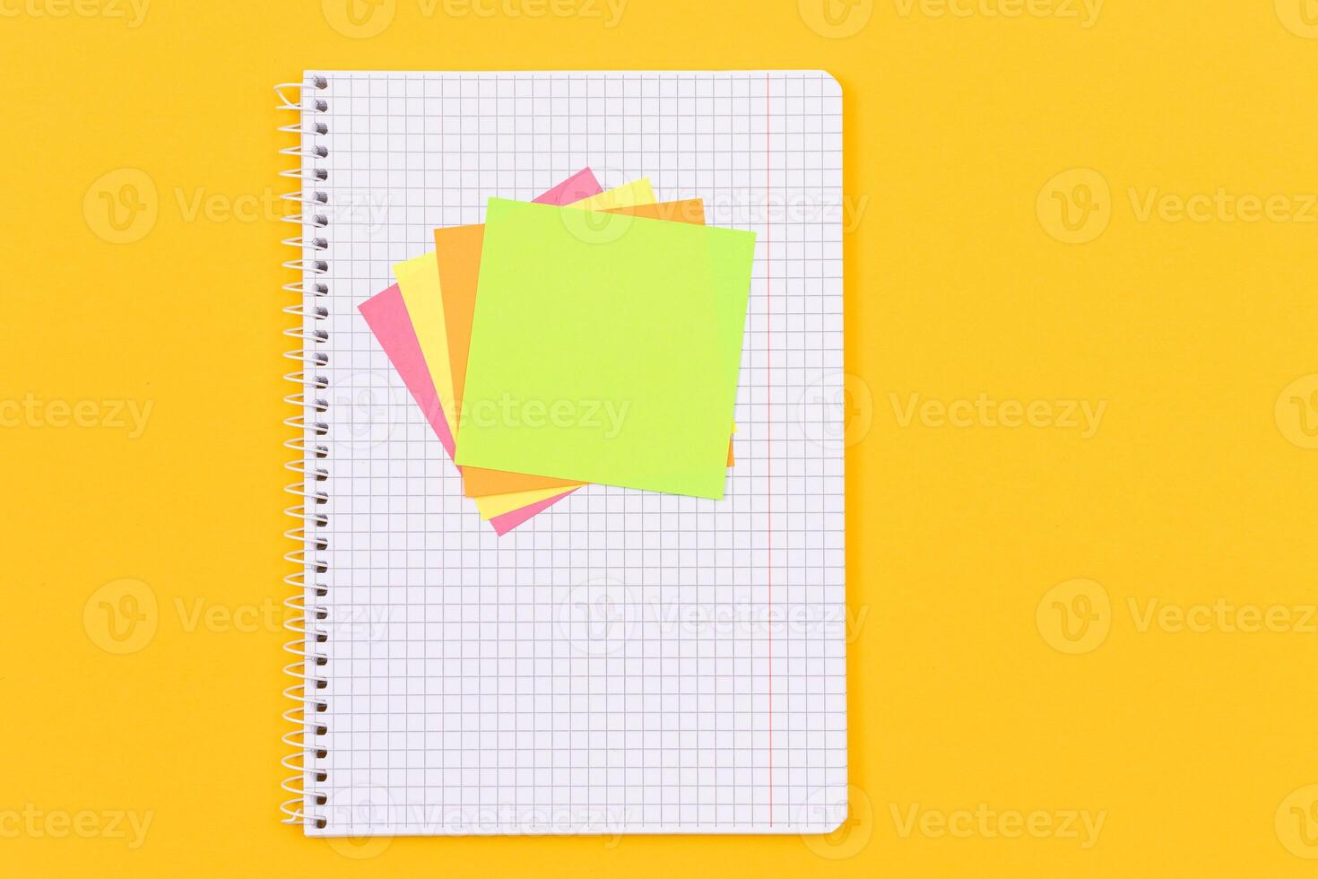A Notepad with Sticky Notes Lying on Yellow Table - Blank Template. Top View, Flat Lay photo
