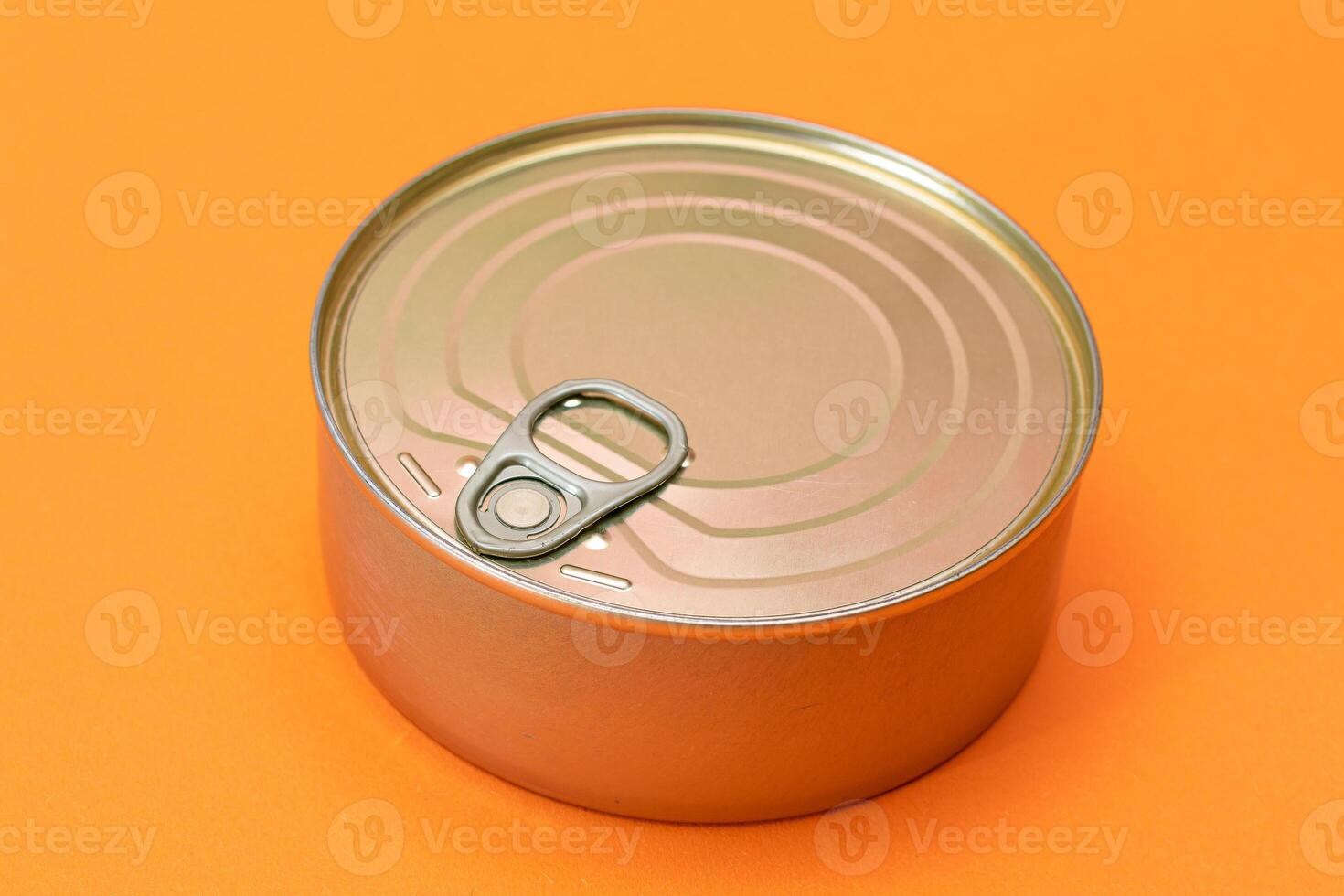 Unopened Tin Can with Blank Edge on Orange Background. Canned Food. Aluminum Can for Safe and Long Term Storage of Food. Steel Sealed Food Storage Container photo