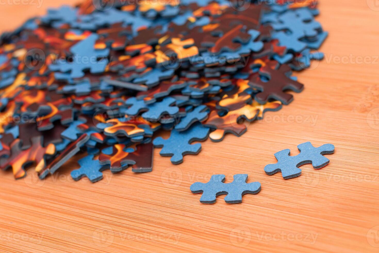 Colorful Pieces of a Mixed Jigsaw Puzzle Lie on the Wooden Table - Strategy and Solving Problem Concept photo