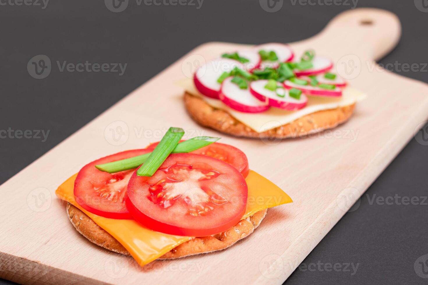 Different Cracker Sandwiches with Tomato, Cucumber, Radish and Cheese on Cutting Board. Easy Breakfast. Diet Food. Quick and Healthy Sandwiches. Crispbread with Tasty Filling. Healthy Dietary Snack photo