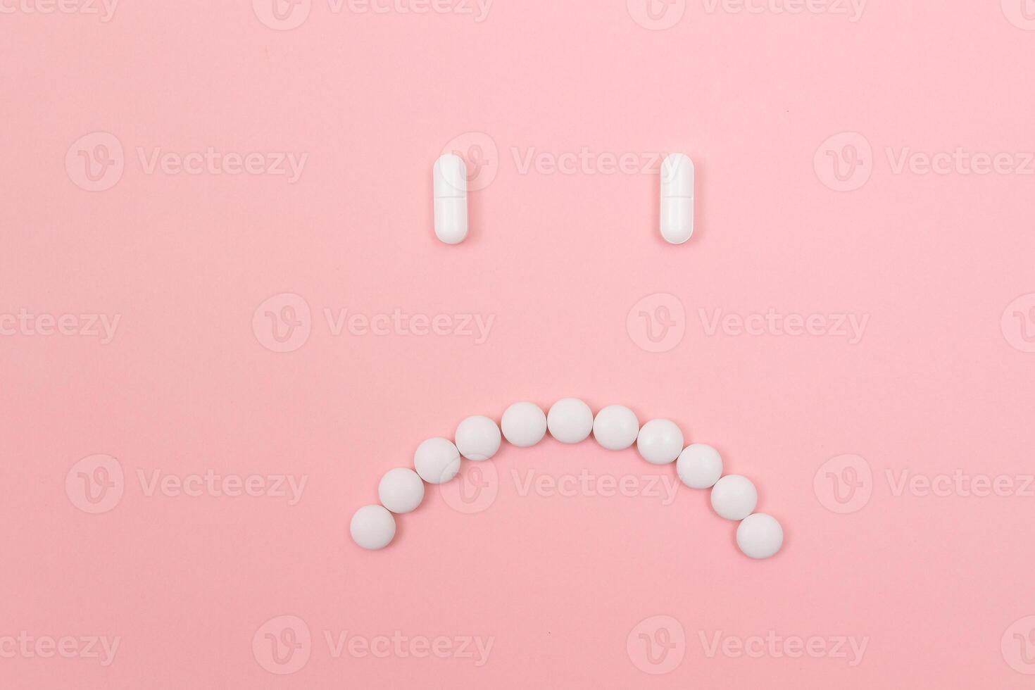 Pharma Harm. Sad Smiley Face Made from White Pills, Lying on Pink Backgrond. Global Pharmaceutical Industry and Medicinal Products photo