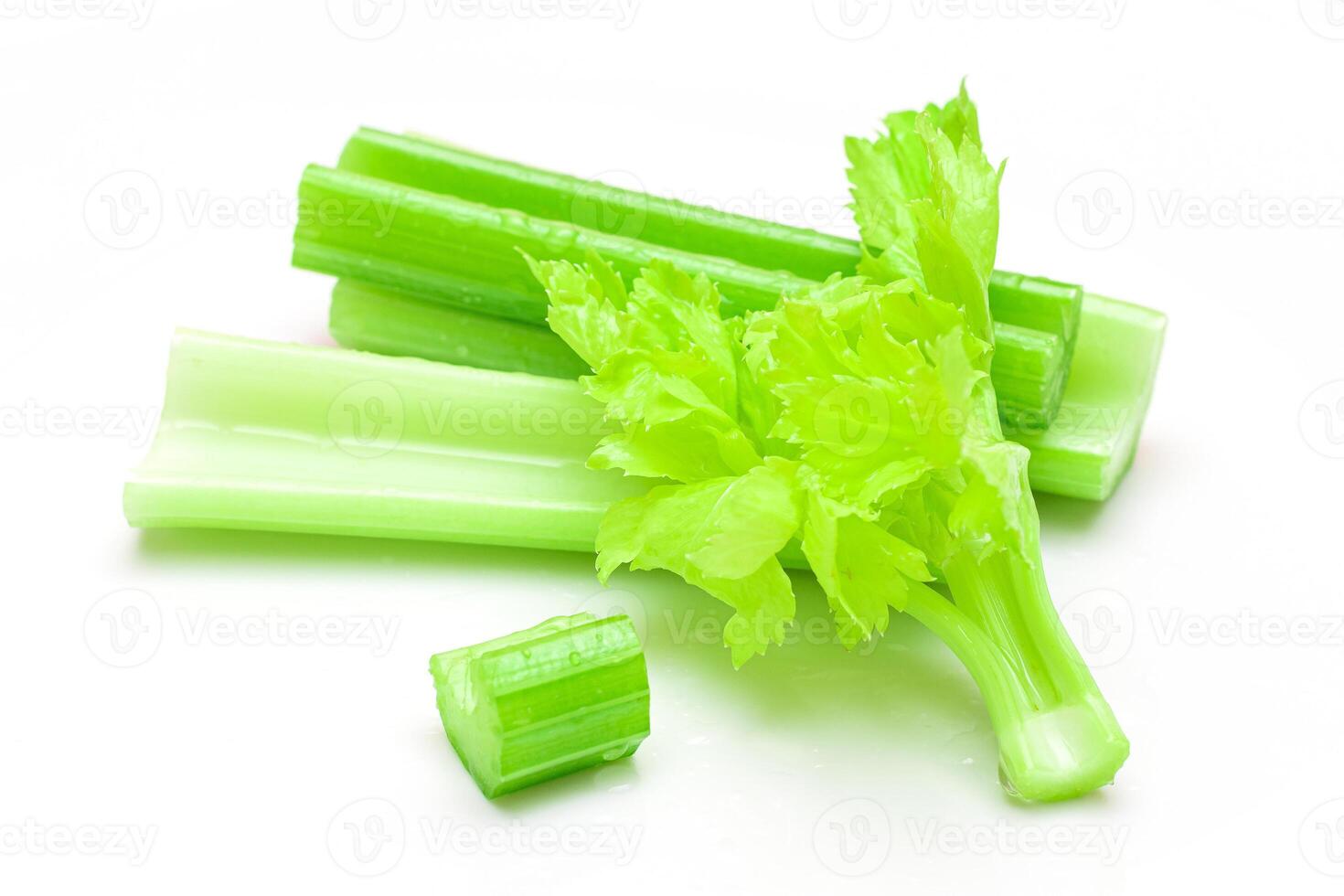 Fresh Chopped Celery Sticks and Slices with Leaves and Water Drops Isolated on White Background. Vegan and Vegetarian Culture. Raw Food. Healthy Diet with Negative Calorie Content photo
