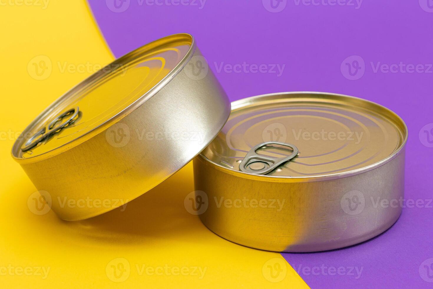 A Group of Stacked Tin Cans with Blank Edges on Split Yellow and Violet Background. Canned Food. Different Aluminum Cans for Safe and Long Term Storage of Food. Steel Sealed Food Storage Containers photo