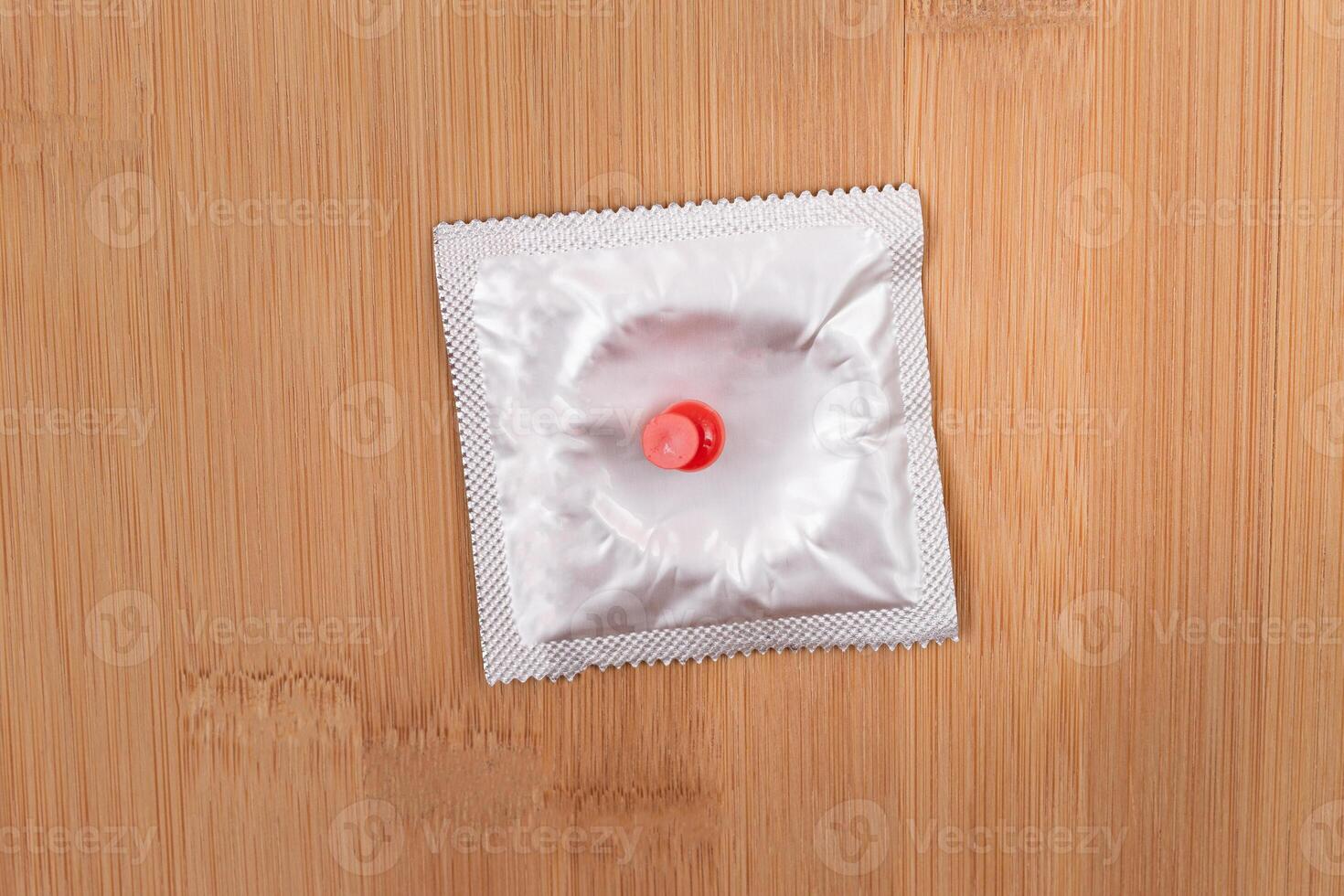 A Joke on Colleagues, Freebie or a Defective Condom - Packaged Latex Condom Pinned to a Wooden Message Board photo