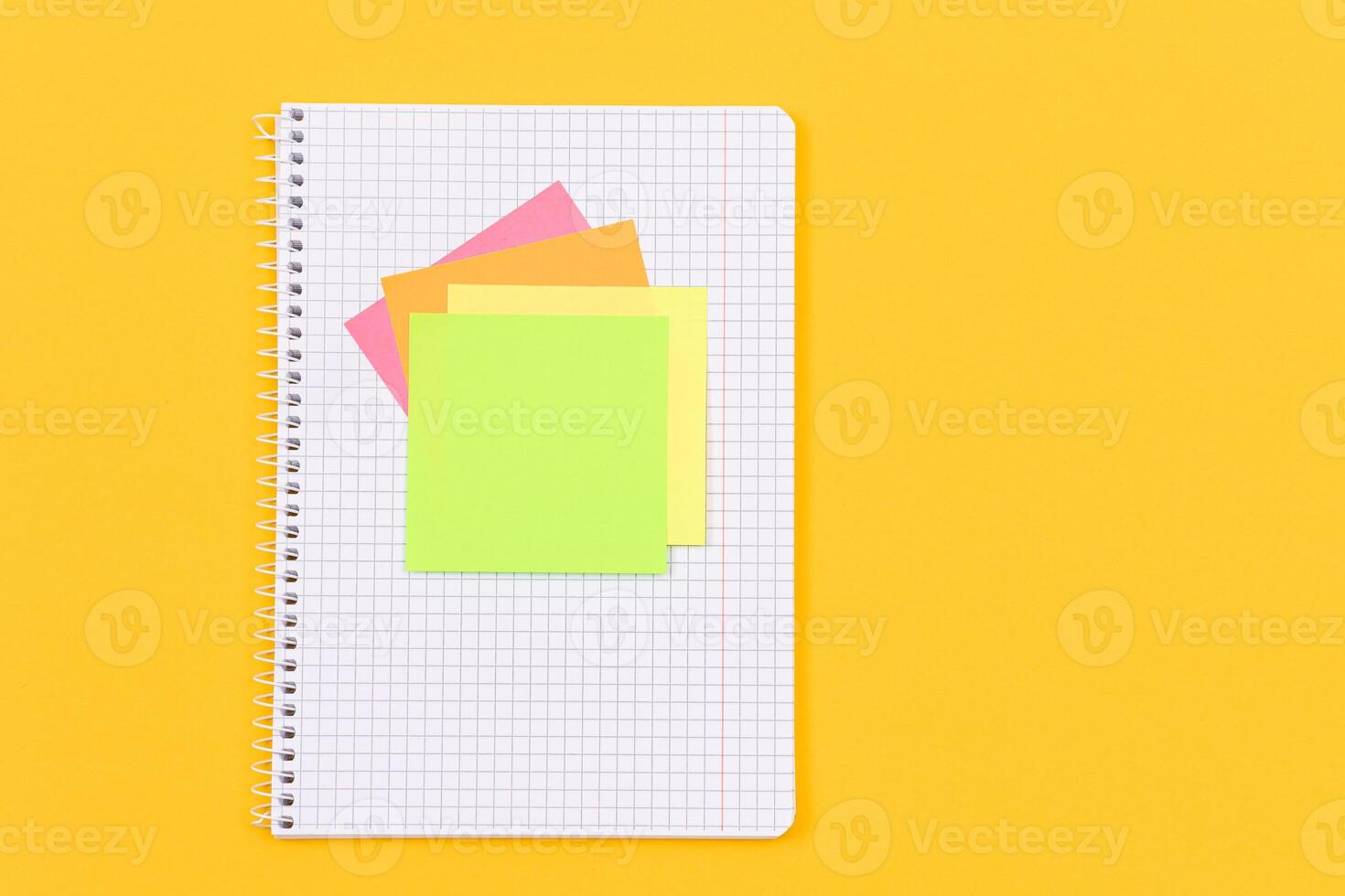 A Notepad with Sticky Notes Lying on Yellow Table - Blank Template. Top View, Flat Lay photo