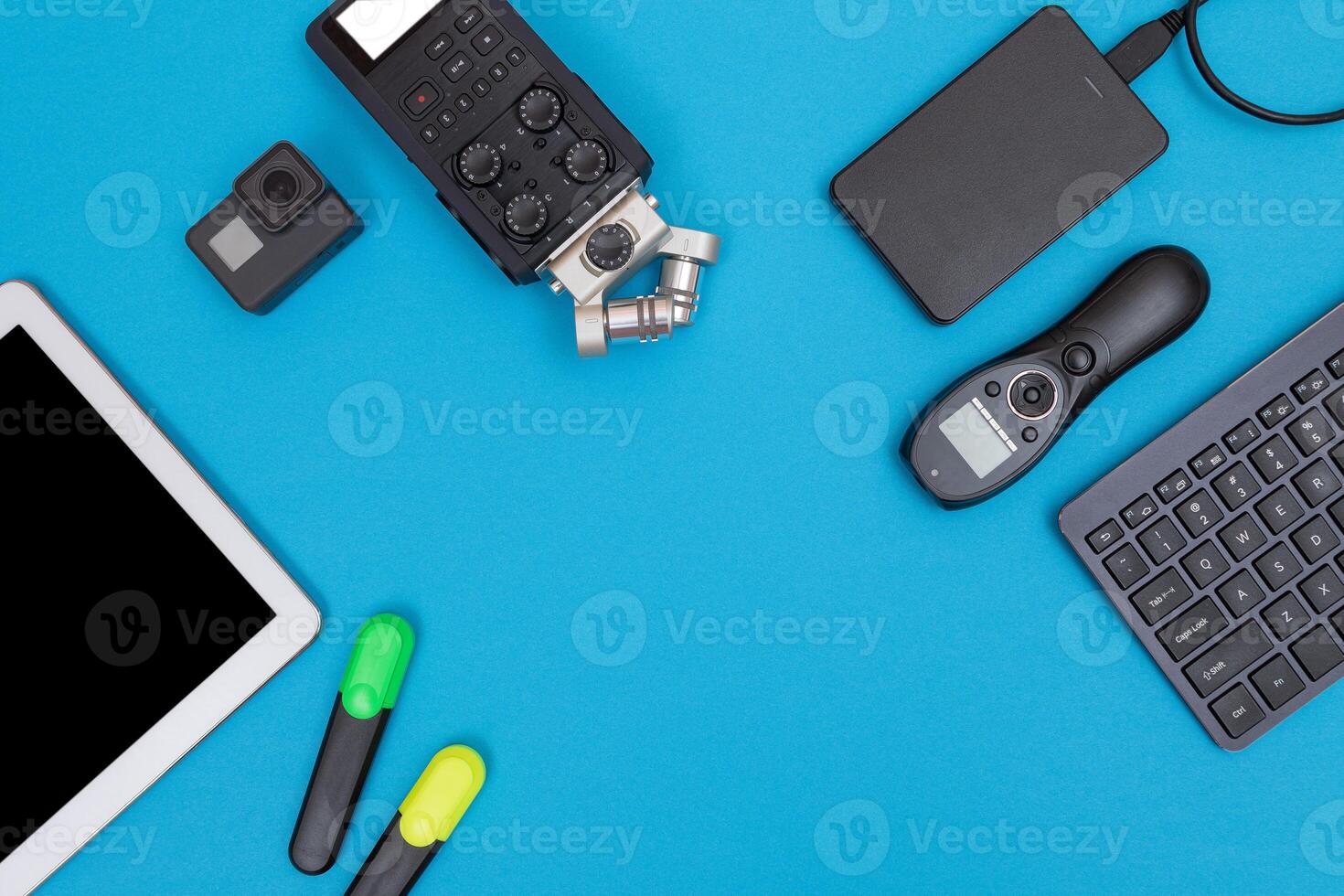 Top View of Photographer's, Videographer's or Blogger's Workplace. Digital Gadgets Lying on Blue Table - Flat Lay photo