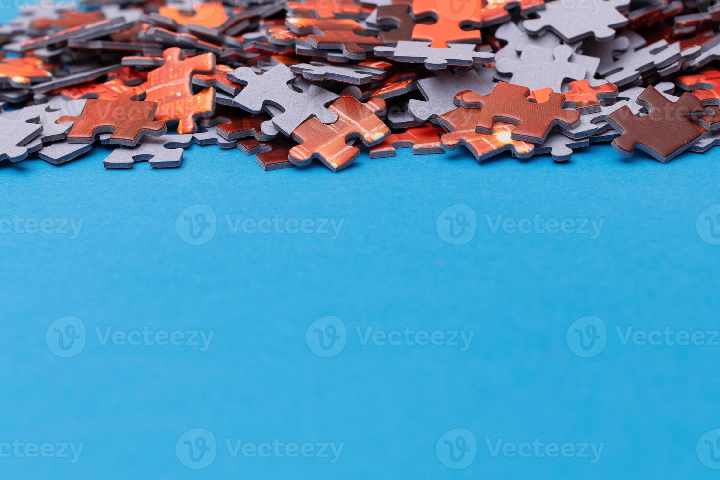 Mixed Pieces of a Colorful Jigsaw Puzzle Lie on the Blue Background With Copy Space - Strategy and Solving Problem Concept photo