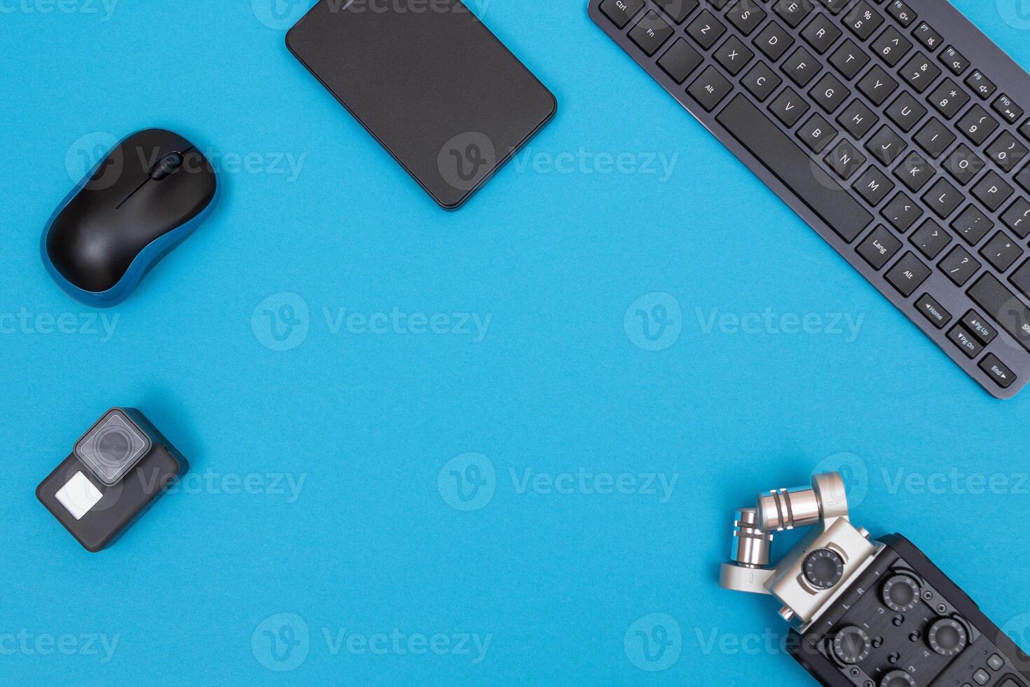 Top View of Photographer's, Videographer's or Blogger's Workplace. Digital Gadgets Lying on Blue Table - Flat Lay photo