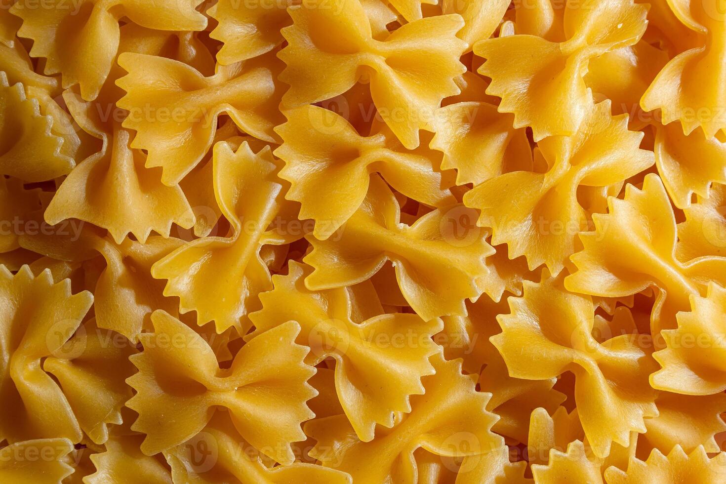 Uncooked Farfalle Pasta. A Culinary Canvas of Bow-Tie Macaroni, Creating a Lively and Textured Background for Gourmet Cooking. Dry Pasta. Raw Macaroni - Top View, Flat Lay photo