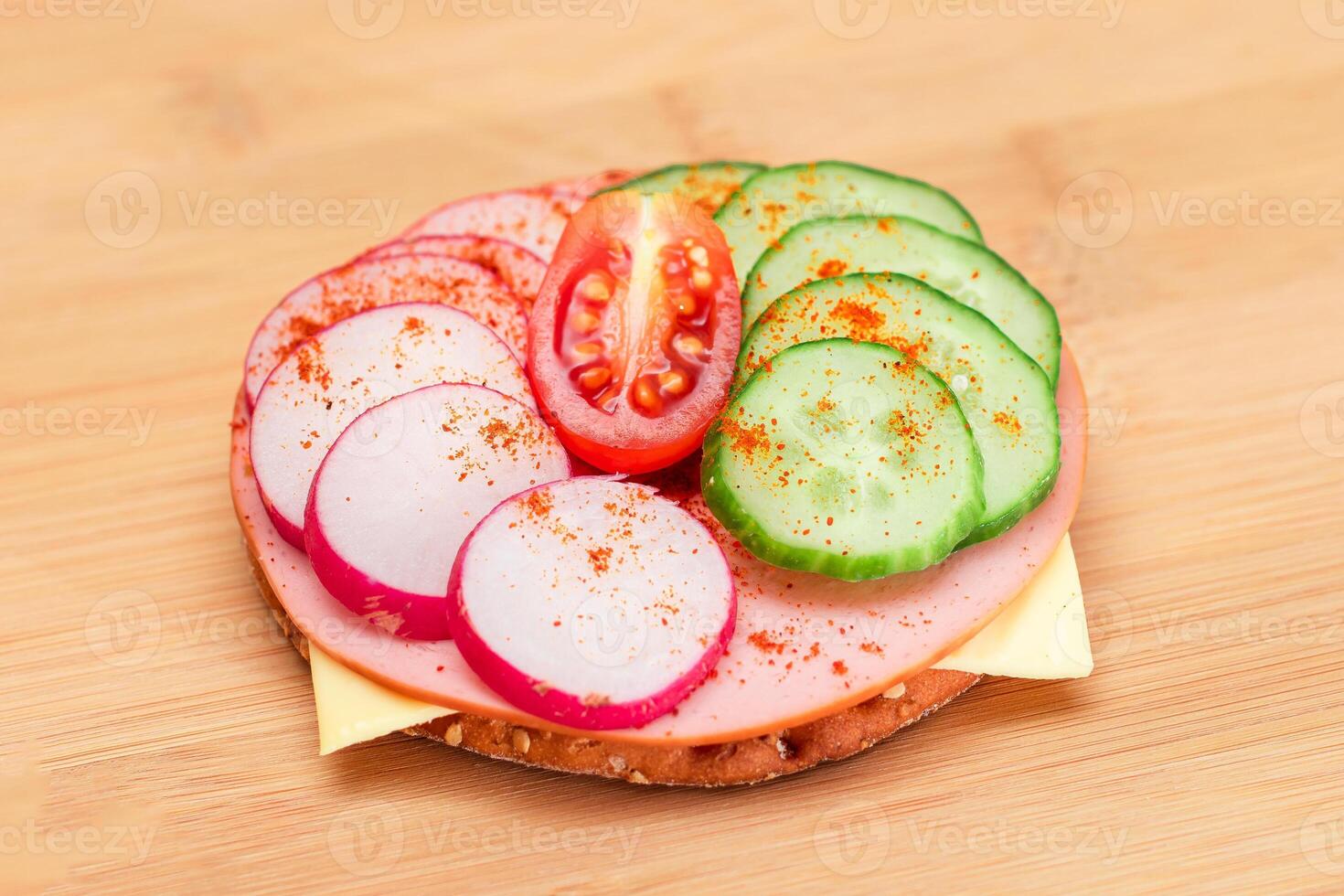 Crispy Cracker Sandwich with Fresh Cucumber, Cheese, Sausage, Radish and Tomato on Cutting Board. Easy Breakfast. Quick and Healthy Sandwiches. Crispbread with Tasty Filling. Healthy Dietary Snack photo