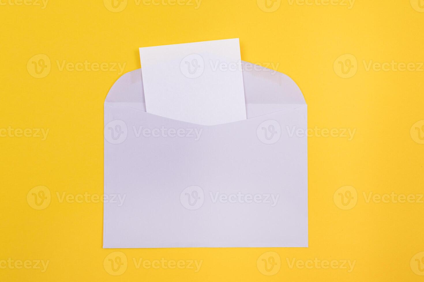 Violet Envelope with Blank White Sheet of Paper Inside, Lying on Yellow Background - Mock Up with Copy Space. Receiving Mail or Notice, Sending Postcard - Top View, Flat Lay photo