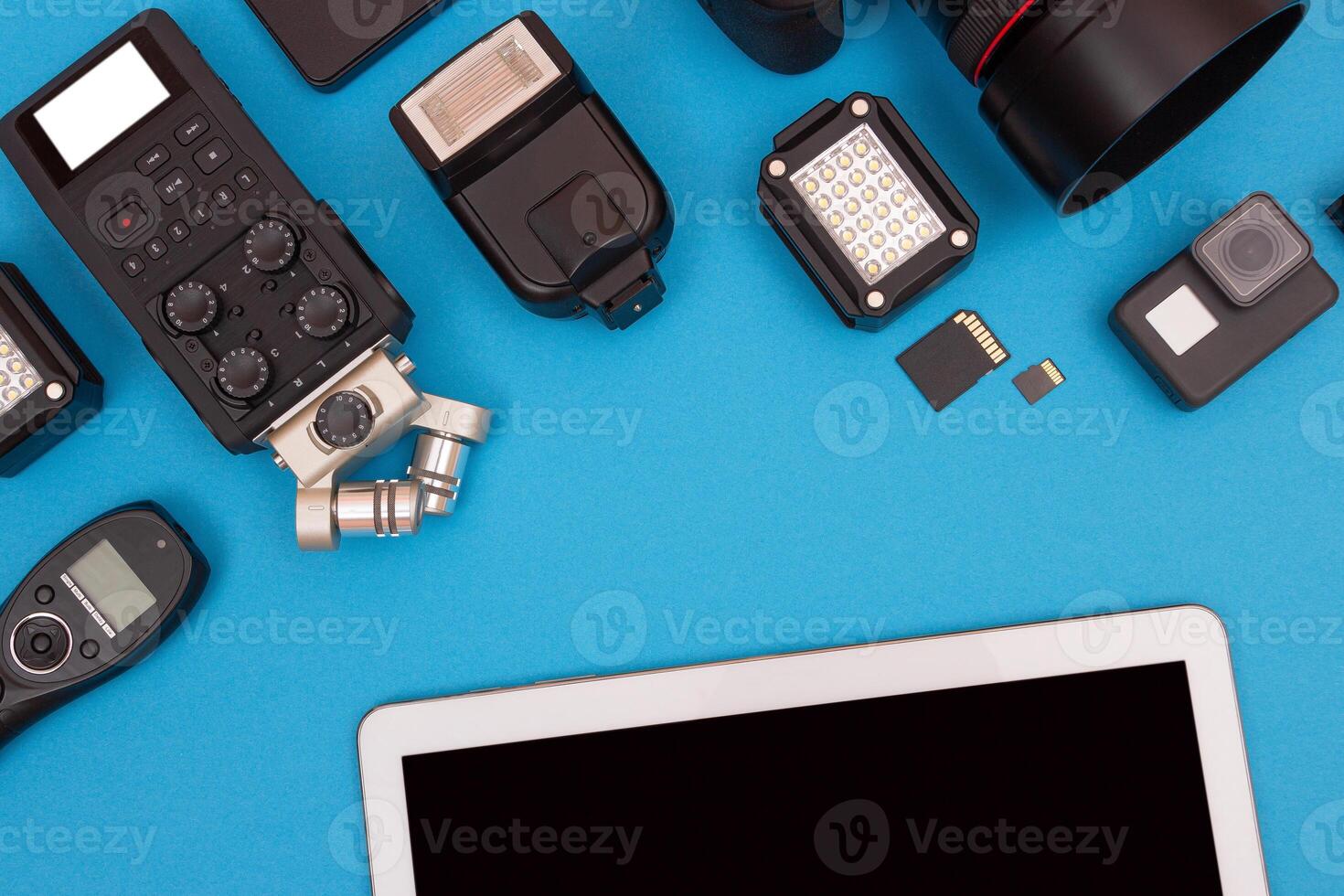 Top View of Photographer's, Videographer's or Blogger's Workplace. Digital Gadgets Lying on Blue Table - Flat Lay photo