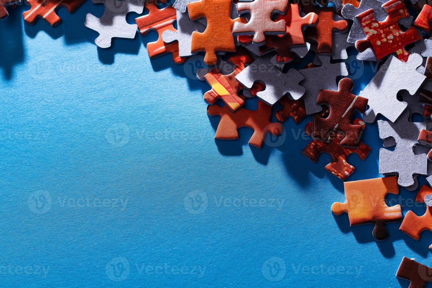 Mixed Pieces of a Colorful Jigsaw Puzzle Lie on the Blue Background With Copy Space - Strategy and Solving Problem Concept photo
