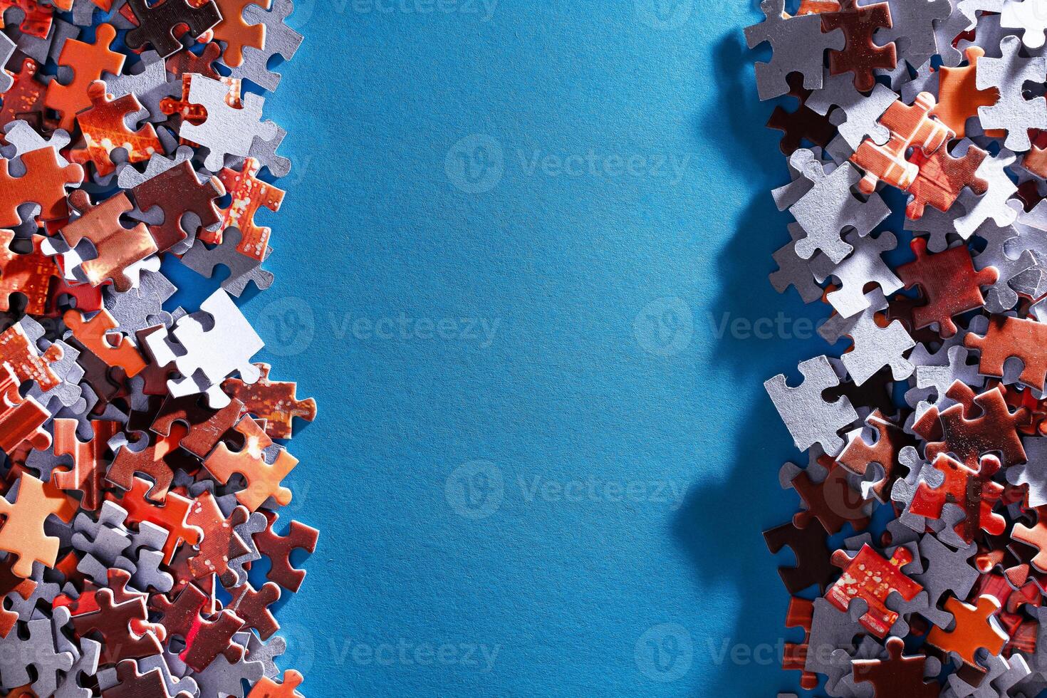 Mixed Pieces of a Colorful Jigsaw Puzzle Lie on the Blue Background With Copy Space - Strategy and Solving Problem Concept photo