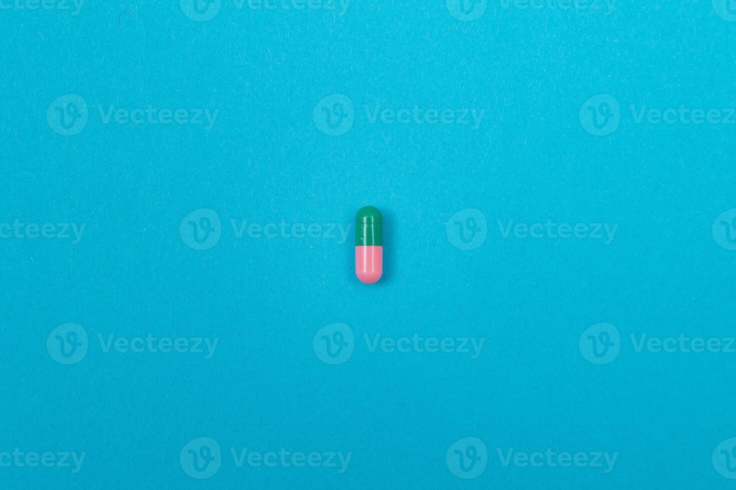 Global Pharmaceutical Industry and Medicinal Products - Colored Pills or Capsules Scattered on Blue Background photo
