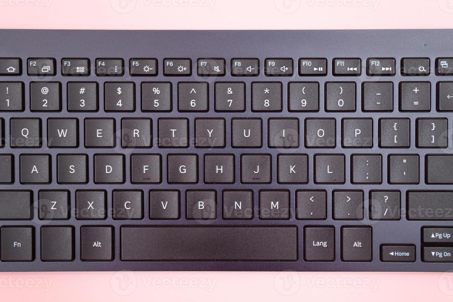 Black Bluetooth Keyboard for Tablet or PC on Pink Background photo