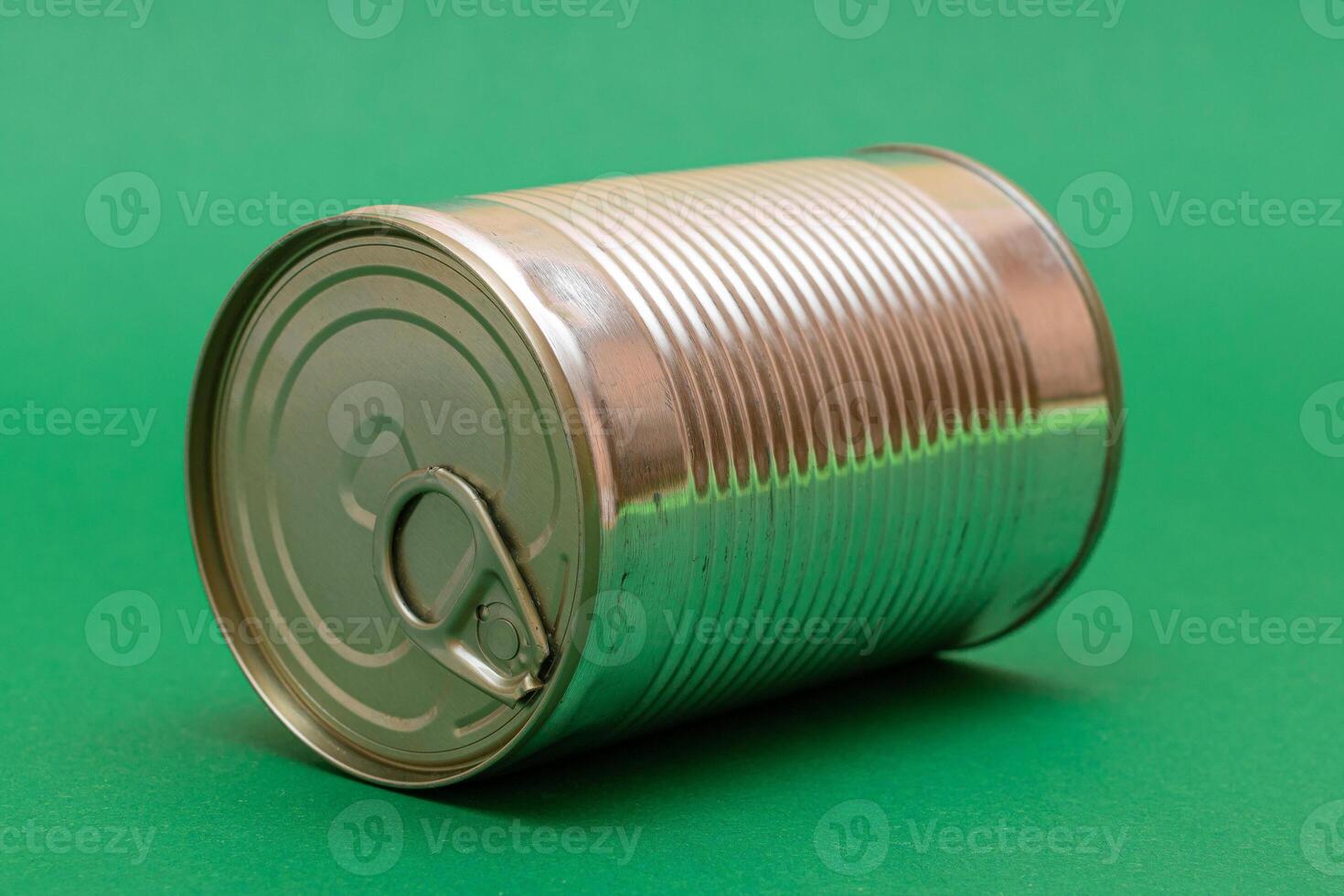 Unopened Tin Can with Blank Edge on Green Background. Canned Food. Aluminum Can for Safe and Long Term Storage of Food. Steel Sealed Food Storage Container photo