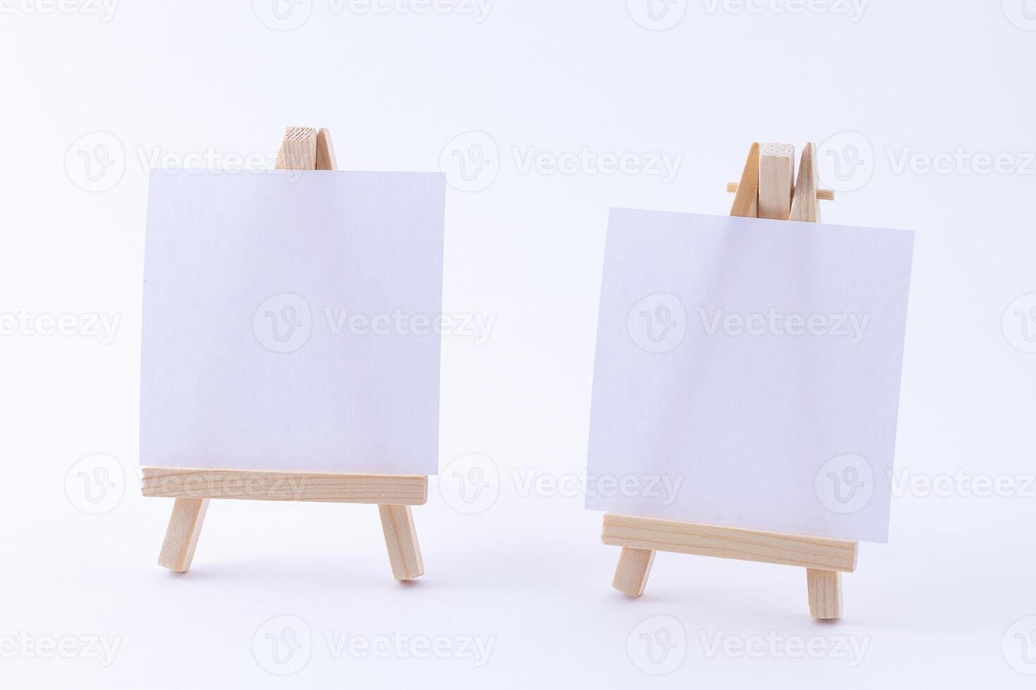 Two Wooden Easels Miniature with Blank White Square Canvas for Artists and Painters - Mockup. Mini Wooden Stand with Clean Artboard on White Background, Copy Space photo