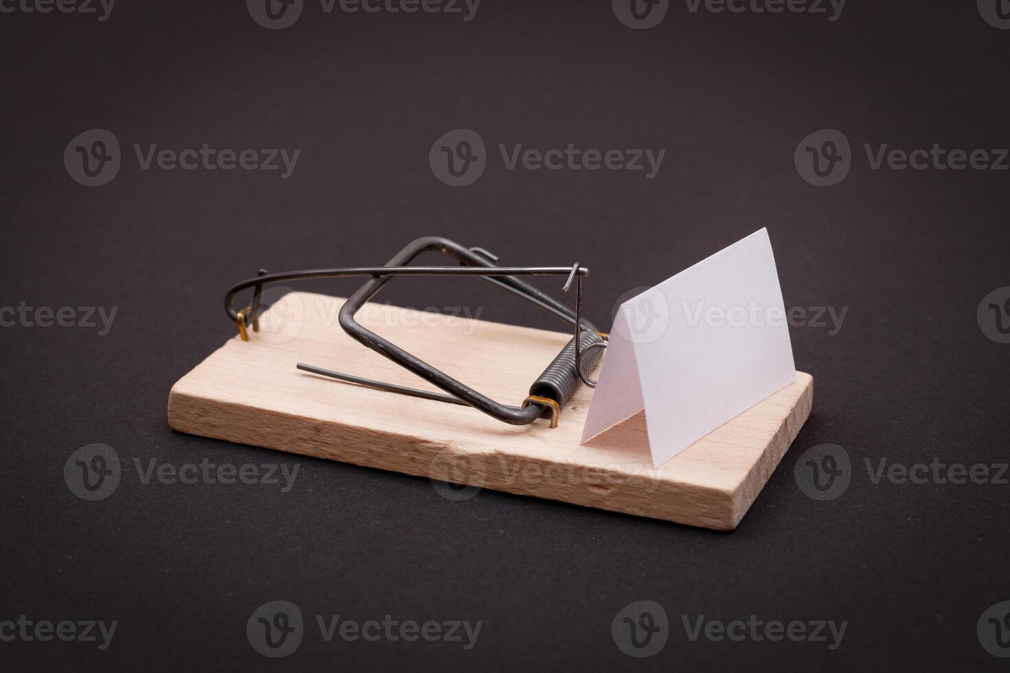 Blank White Sheet of Paper in Wooden Mousetrap - Template. Small Memo Paper in Mouse Trap on Black Background photo