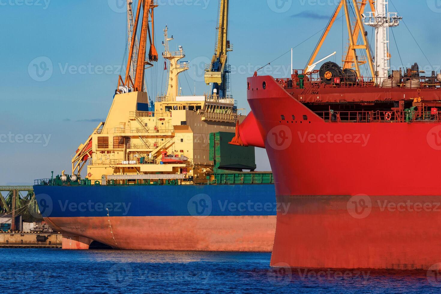 Red and blue cargo ship loading in the port of Riga photo