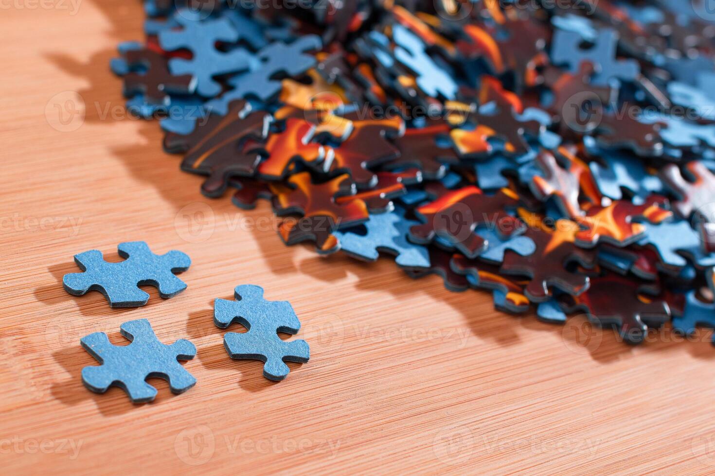 Colorful Pieces of a Mixed Jigsaw Puzzle Lie on the Wooden Table - Strategy and Solving Problem Concept photo