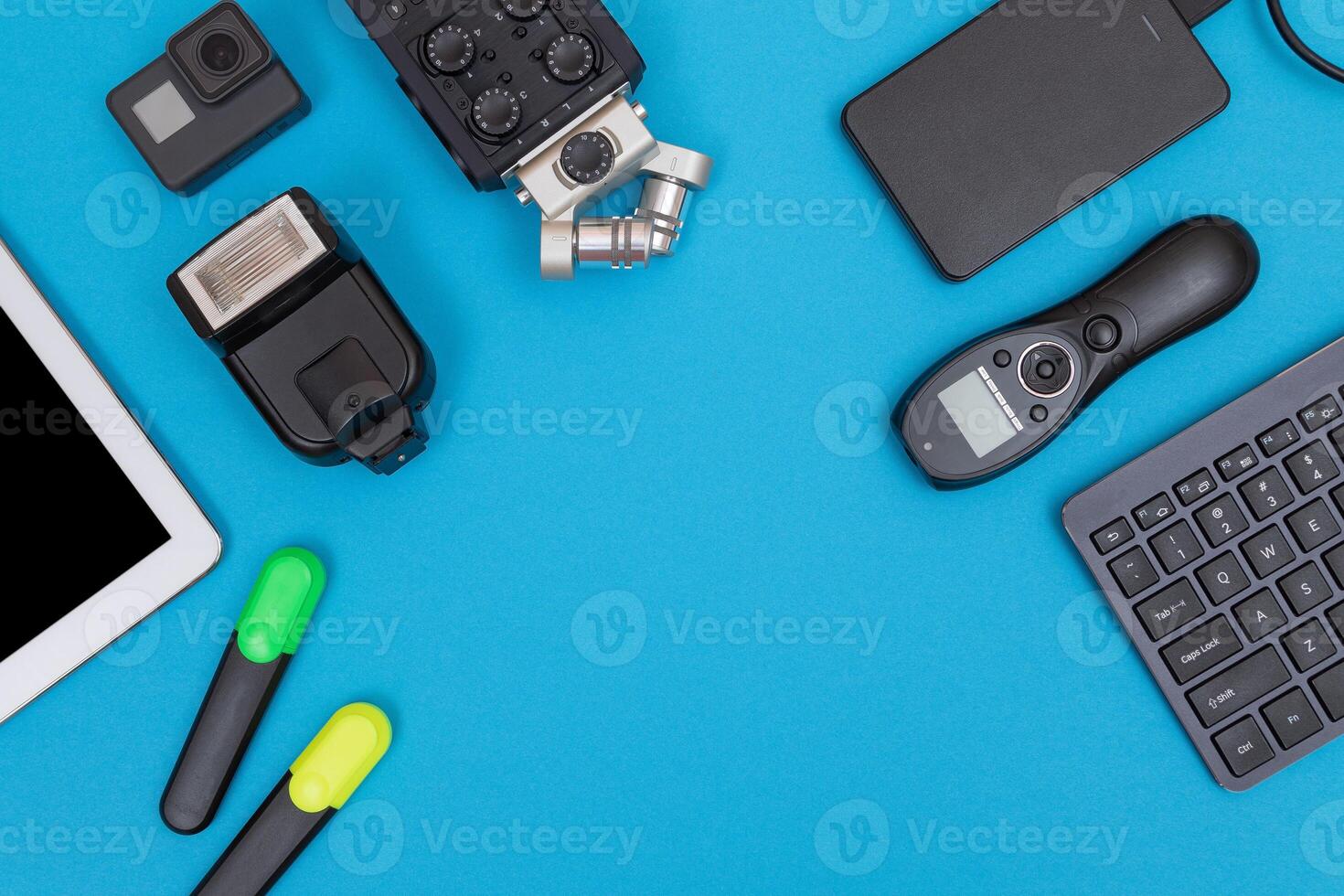 Top View of Photographer's, Videographer's or Blogger's Workplace. Digital Gadgets Lying on Blue Table - Flat Lay photo