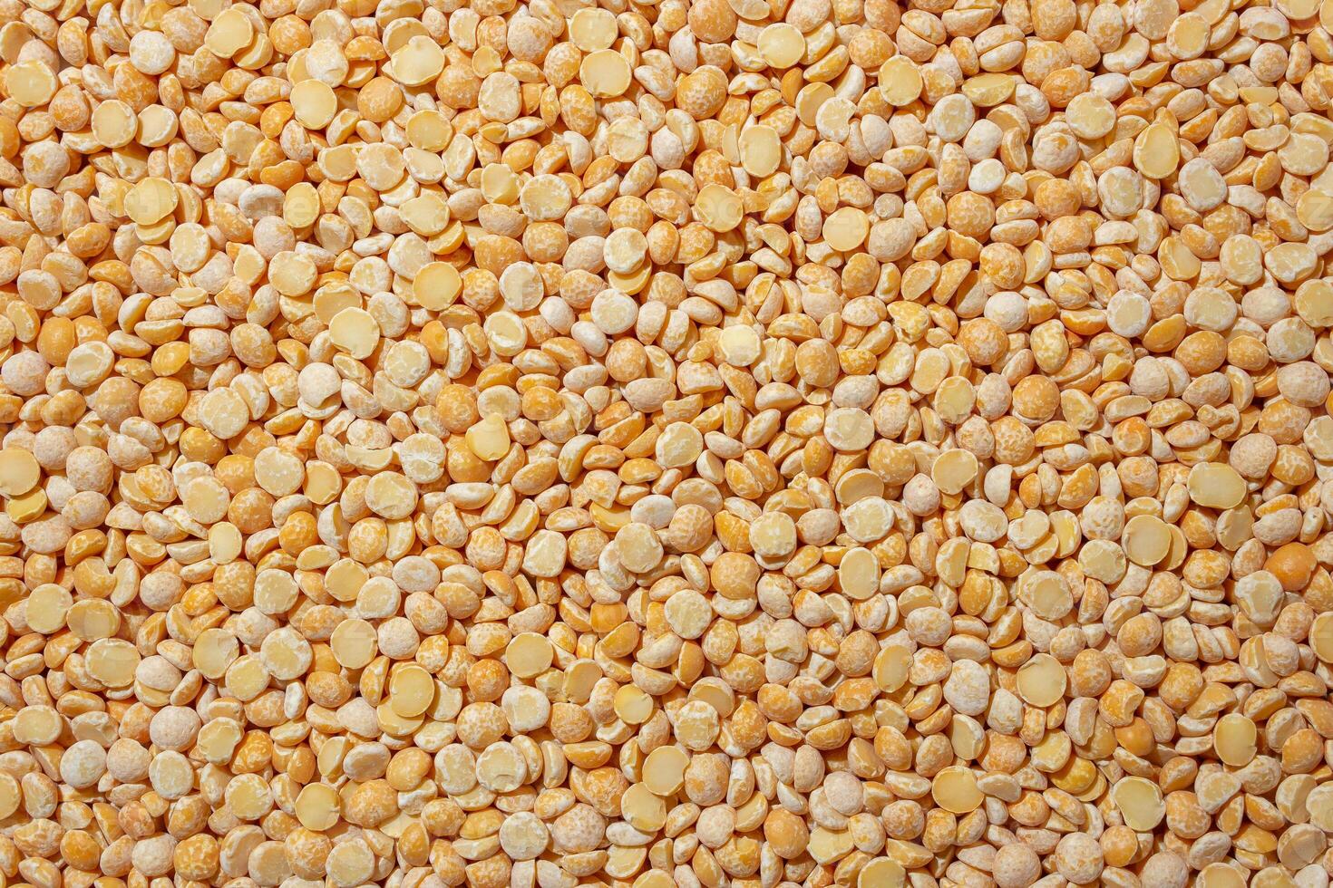 Uncooked Polished Split Peas Background. A Culinary Canvas of Dry Yellow Peas, Creating a Lively and Textured Background for Gourmet Cooking. Scattered Raw Polished Peas. Healthy Eating Ingredients photo