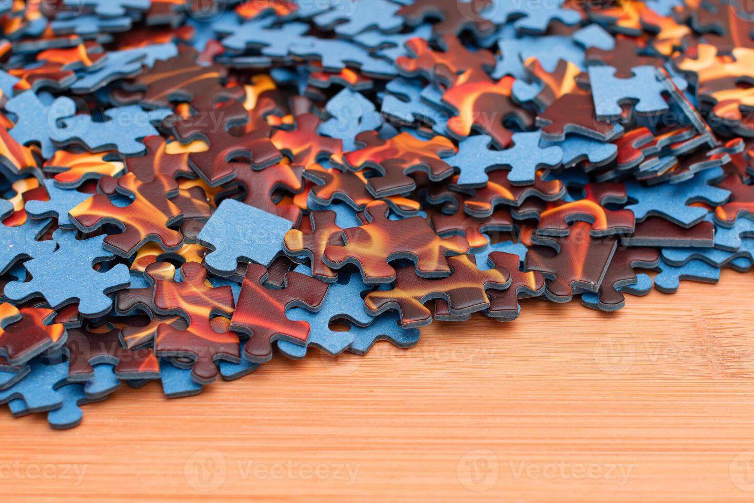 Colorful Pieces of a Mixed Jigsaw Puzzle Lie on the Wooden Table - Strategy and Solving Problem Concept photo