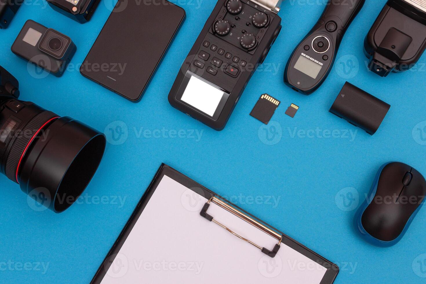 Top View of Photographer's, Videographer's or Blogger's Workplace. Digital Gadgets Lying on Blue Table - Flat Lay photo